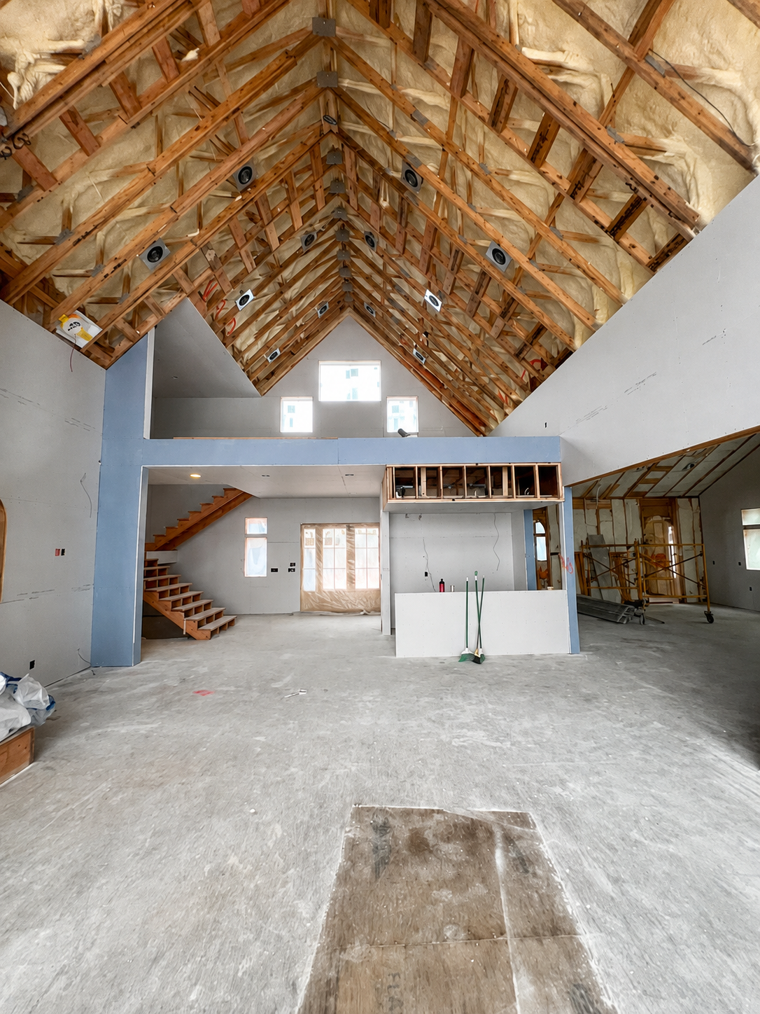 Large vaulted great room with open trusses and finished walls below