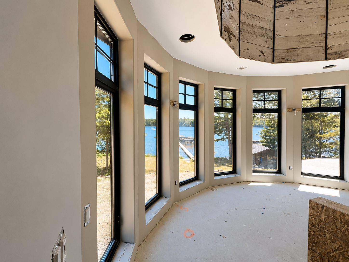 Finished drywall detail showing crisp corners, smooth seams and a long curved wall plane in a lakeside home