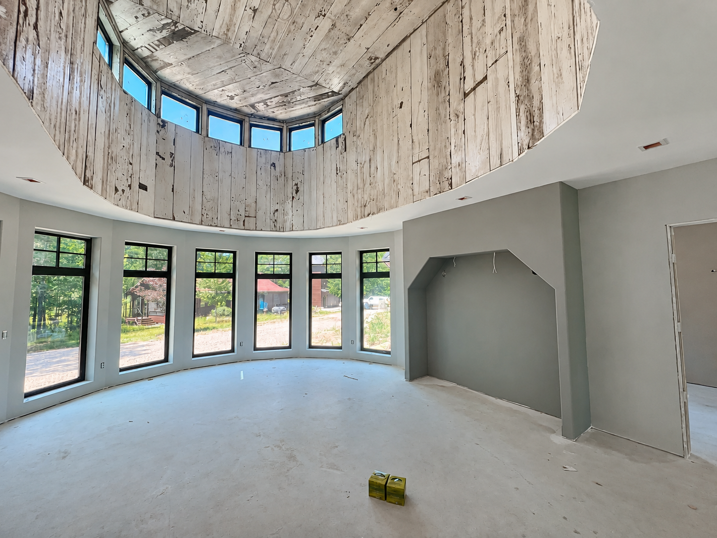 High-level smooth finish in a curved great room with tall windows